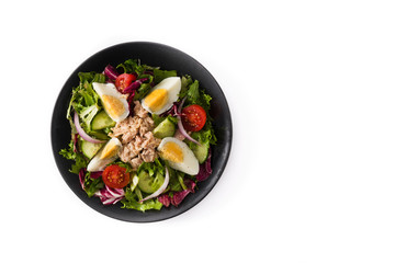 Salad with tuna, egg and vegetables isolated on white background. Top view. Copy space