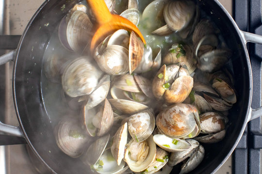 Close up of steamed clams in shells with green onions