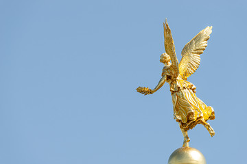Old statue of a golden angel as a warrior and defender at the dome top of the central historical...