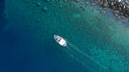 Aerial drone photo of traditional wooden fishing boat in old port of Mykonos island,  Cyclades, Greece
