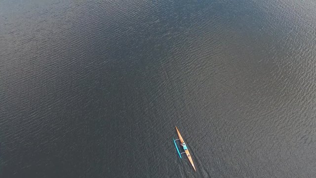  Canoeing competition-rowing boating sport. Athletes rowers on outrigger canoe boats with stabilizer in the river water area. Aerial survey