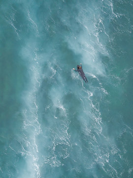 Aerial view of a man surfing at an agitated sea near Lo?inj coastline, Croatia.