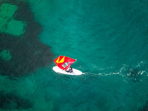 Aerial view of man practicing kitesurfing at transparent water, Croatia.