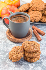 Spicy pumpkin and oatmeal cookies with cup of coffee, vertical