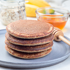 Healthy oatmeal banana pancakes on  gray plate, square format