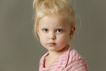 Studio headshot of two years old toddler girl looking at camera