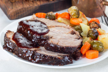Pork shoulder in honey parmesan and soy souse, prepared in slow cooker or crockpot, served with carrot, potato and brussel cabbage, on white plate, horizontal , closeup
