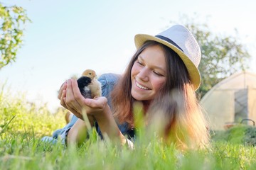 Portrait of beautiful girl on farm with two newborn chicks in hand © Valerii Honcharuk