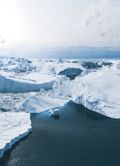 Iceberg and ice from glacier in arctic nature landscape in Ilulissat,Greenland. Aerial drone photo of icebergs in Ilulissat icefjord. Affected by climate change and global warming. © Mathias