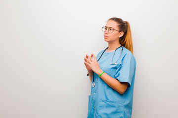 young latin nurse scheming and conspiring, thinking devious tricks and cheats, cunning and...
