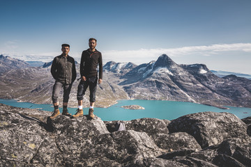 Two young man happy traveler on top of mountain in Greenland, Nuuk. nature mountain landscape aerial drone photo showing amazing greenland landscape near Nuup Kangerlua fjord seen from Ukkusissat