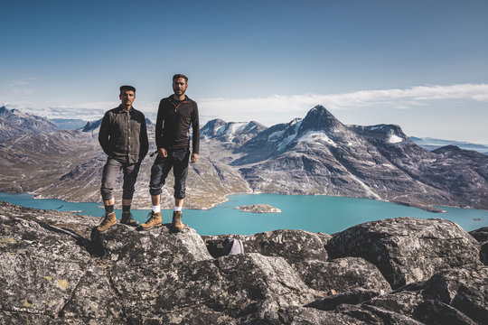 Two young man happy traveler on top of mountain in Greenland, Nuuk. nature mountain landscape aerial drone photo showing amazing greenland landscape near Nuup Kangerlua fjord seen from Ukkusissat