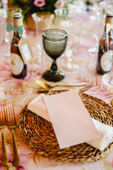 Elegant centerpieces with golden cutlery for a wedding, with a white empty card on the napkin to place text.