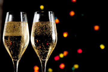 Two champagne glasses and lights unfocused