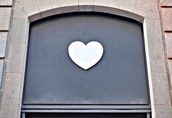White heart on a dark background above the entrance.