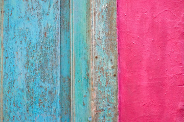 Fragment of vintage surfaces in pink and blue pastel colors, bright wall and an old timber door frame, abstract old architecture detail.