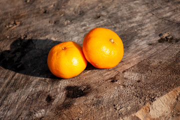 Two fresh unpeeled tangerines on wooden background