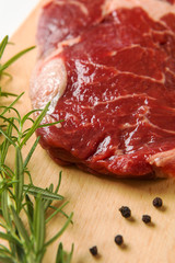 Raw seasoned beef slice on a wooden board