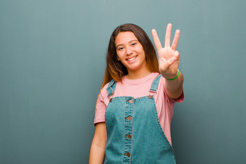 young pretty latin woman smiling and looking friendly, showing number three or third with hand...