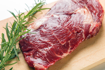 Raw seasoned beef slice on a wooden board