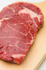 Raw seasoned beef slice on a wooden board