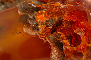 Amber. Fantastically beautiful and unusual background. Colorful patterns. Natural mineral from fossilized ancient resin of wood. Sun stone with inclusions inside. Digging texture. Magic drawing