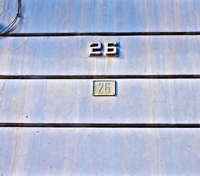 Numbers 26, twenty-six, on old weathered blue wall.