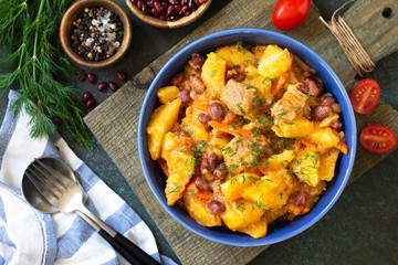 Thanksgiving Autumn Menu. Stew with beans and vegetables in a bowl on a rustic table. Top view of a flat lay with copy space.