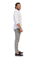 Fototapeta premium Side View Of Elegant Man Standing And Looking At Camera