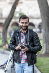 Photographer with beard and photographic camera outdoor.