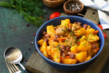 Thanksgiving Autumn Menu. Stew with beans and vegetables in a bowl on a rustic table. Copy space.