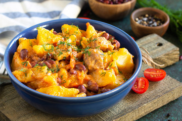 Thanksgiving Autumn Menu. Stew with beans and vegetables in a bowl on a rustic table.