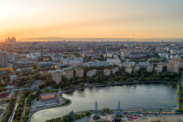 Obraz premium Big city aerial shot. Long and wide streets filled with cars. Shooting in the evening with the setting sun.