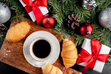 Christmas coffee and croissants with Christmas tree and gifts, toys on a stone background