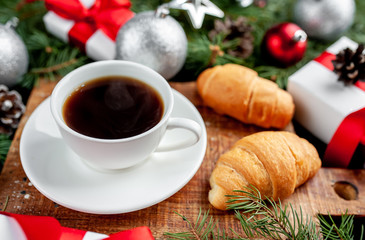 Christmas coffee and croissants with Christmas tree and gifts, toys on a stone background