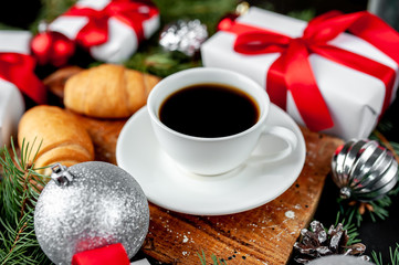 Christmas coffee and croissants with Christmas tree and gifts, toys on a stone background