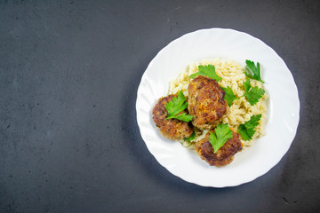 boiled pasta with meatballs on a white plate on a wooden board