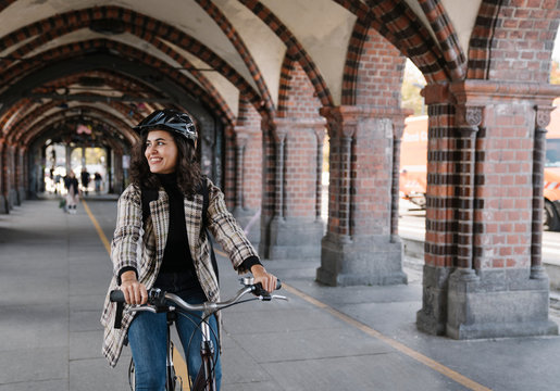 Happy woman riding bicycle in the city, Berlin, Germany
