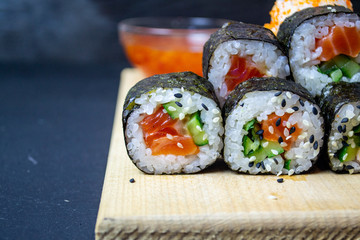 red fish sushi on a wooden tray
