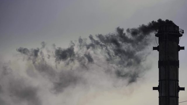 Black smoking pipes, air pollution concept. Industrial factory pollution, global warming. Industrial zone with big pipe smoking, black smoke. Environmental problems.