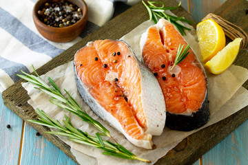 Fresh organic fish. Salmon steaks on a wooden cutting board with spices.