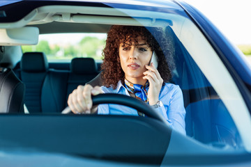 Woman with smart phone in a car.