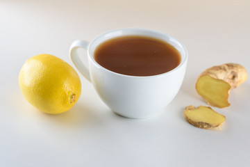 Tea, ginger root and lemon on wooden background with copy space.