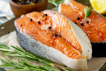 Fresh organic fish. Salmon steaks on a wooden cutting board with spices. Top view on a flat background lay. Copy space.