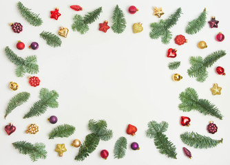 Christmas or New Year background: fir tree branches, red glass balls, decoration and cones on a white background