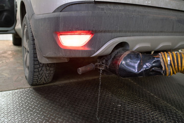 The exhaust exhaust hose is put on the exhaust pipe of the car indoors