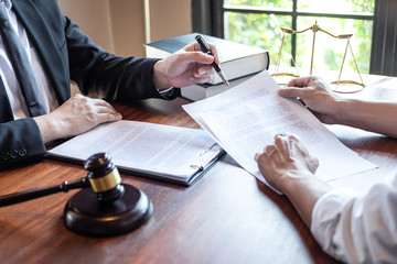 Male lawyer discussing negotiation legal case with client meeting with document contact in courtroom, law and justice concept