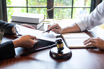 Male lawyer discussing negotiation legal case with client meeting with document contact in courtroom, law and justice concept