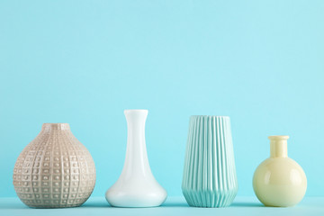 Different ceramic vases on blue background