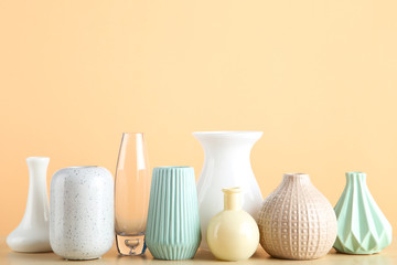 Fototapeta na wymiar Different ceramic vases on beige background